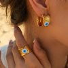Gold evil eye earring and ring set with vibrant blue and white eye detail, perfect for fashion-forward individuals seeking stylish and protective accessories.