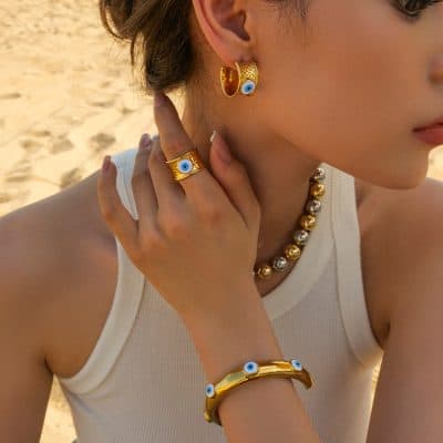 Elegant gold evil eye jewelry, including earrings, ring, bracelet, and necklace, perfect for protection and style. Crafted with eye-catching design for women focused on fashion, tradition, and wellness.