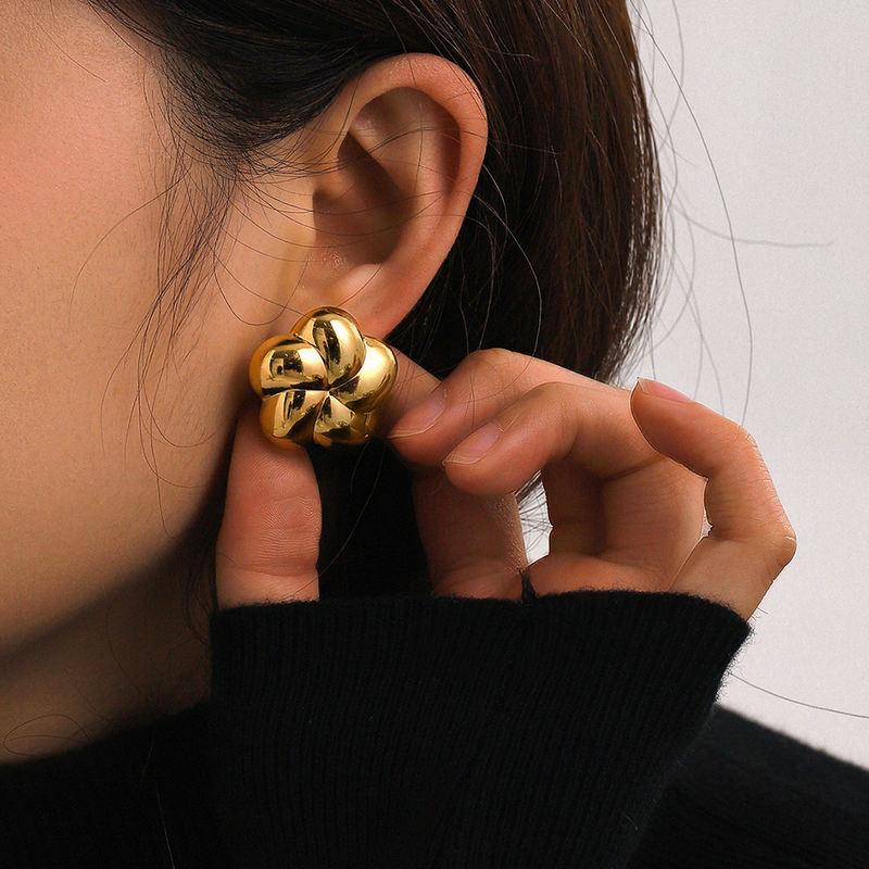 Close-up of a stylish gold flower-shaped earring worn by a woman, showcasing luxury jewelry and modern fashion accessories for eye-catching style.