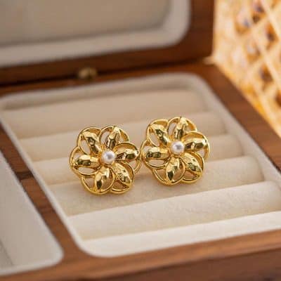 Stylish gold flower earrings with a pearl center, perfect for elegant occasions and daily wear. Made with high-quality materials, these jewelry pieces add a touch of sophistication and charm.