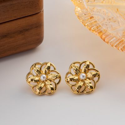 Vintage-inspired gold floral earrings featuring a central pearl, perfect for elegant jewelry collections and special occasions.