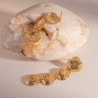 Gold seashell jewelry set featuring earrings and bracelet, ideal for beach-themed accessories, summer fashion, and elegant jewelry collections.