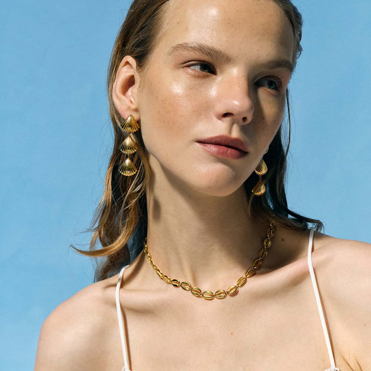 Beautiful woman wearing gold necklaces and earrings, fashionable jewelry accessory for women, stylish and luxurious, perfect for everyday wear or special occasions.