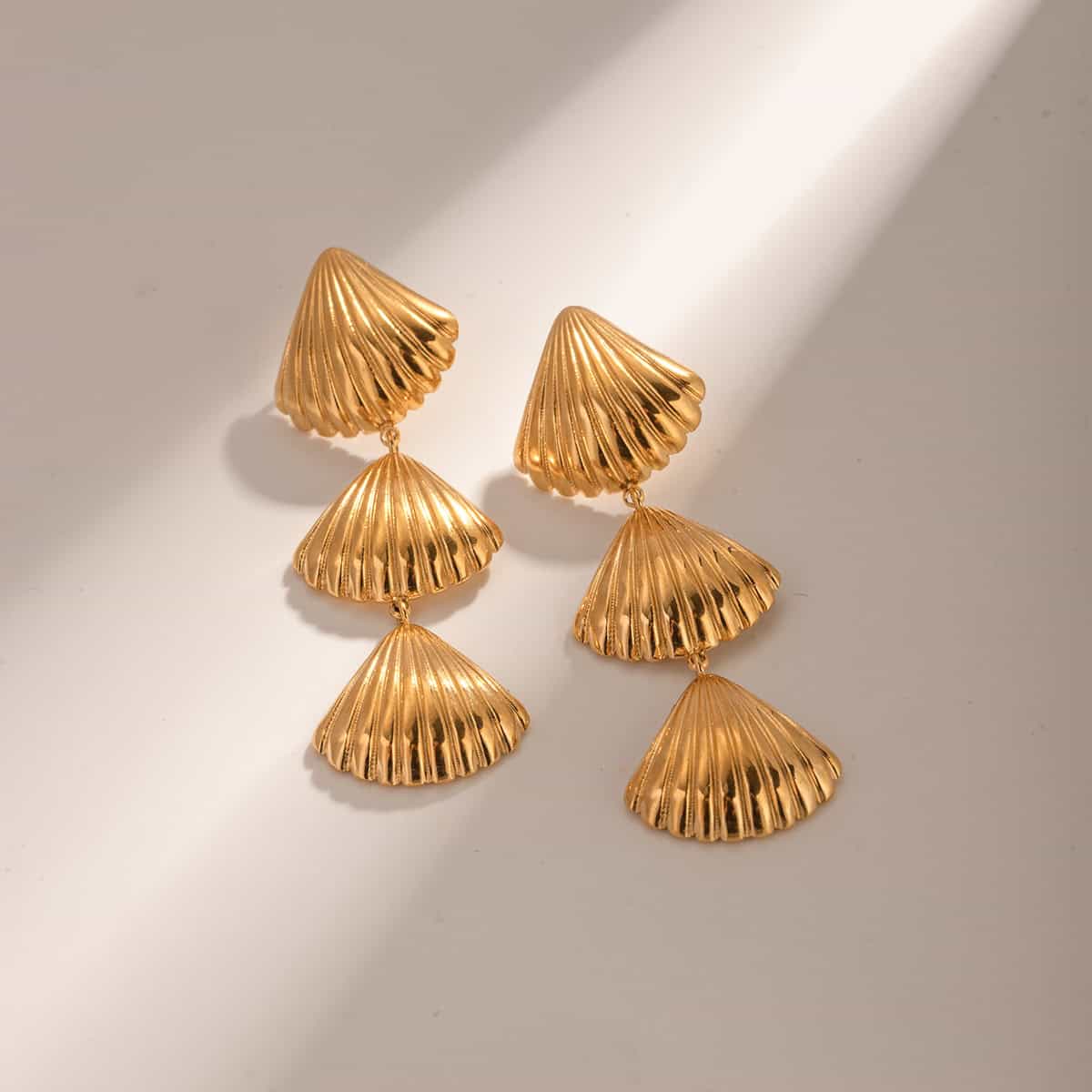 Beautiful gold shell-shaped statement earrings perfect for stylish jewelry collections at Monalisa Medical. Crafted with high-quality materials for a chic, modern look.