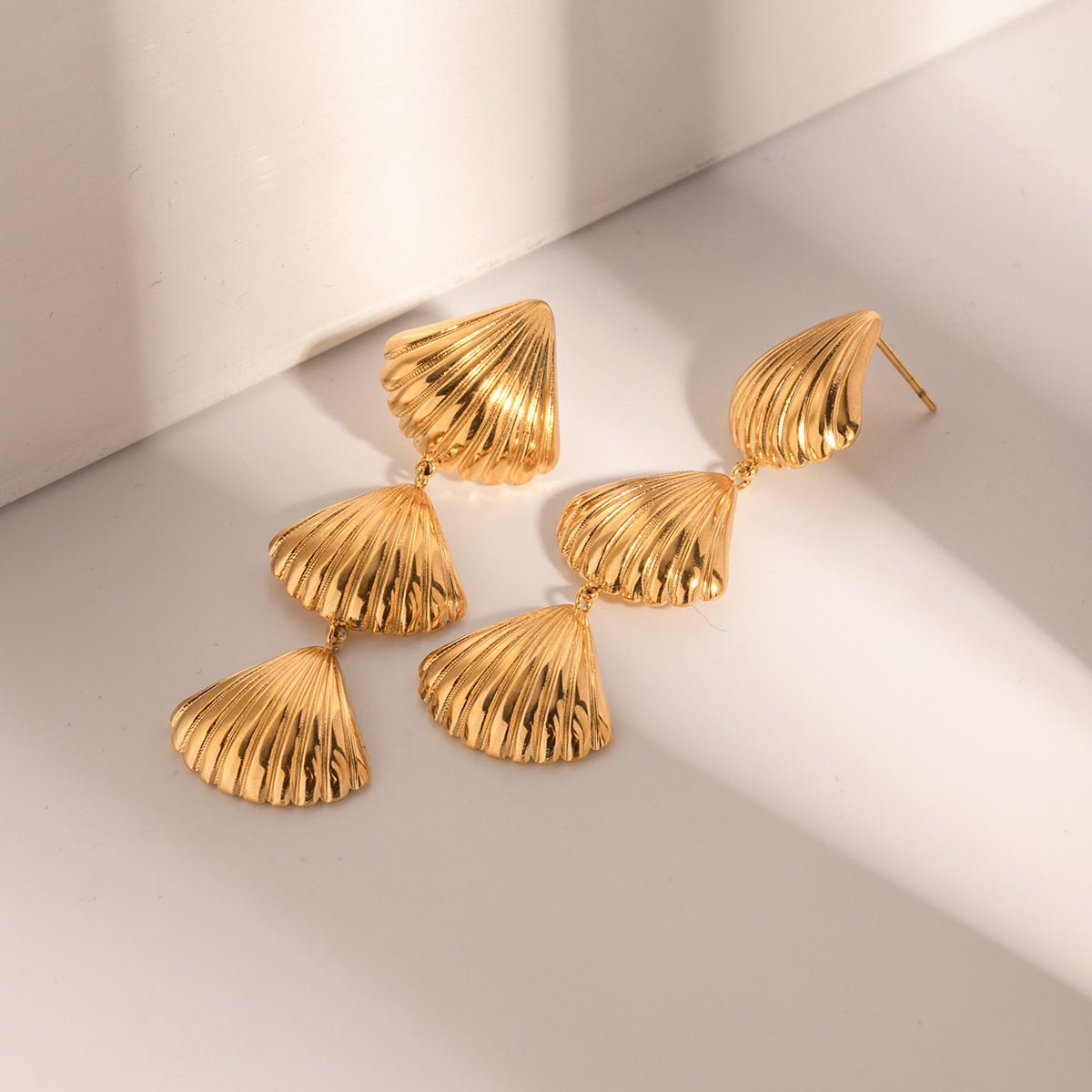 Dainty gold shell-shaped earrings perfect for a stylish look. Crafted with high-quality materials, these earrings offer a chic accessory choice for any occasion.