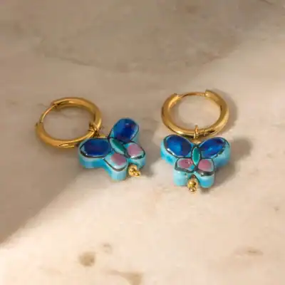 Vibrant butterfly enamel earrings with gold hoop accents, perfect for elegant accessories and stylish jewelry collections.