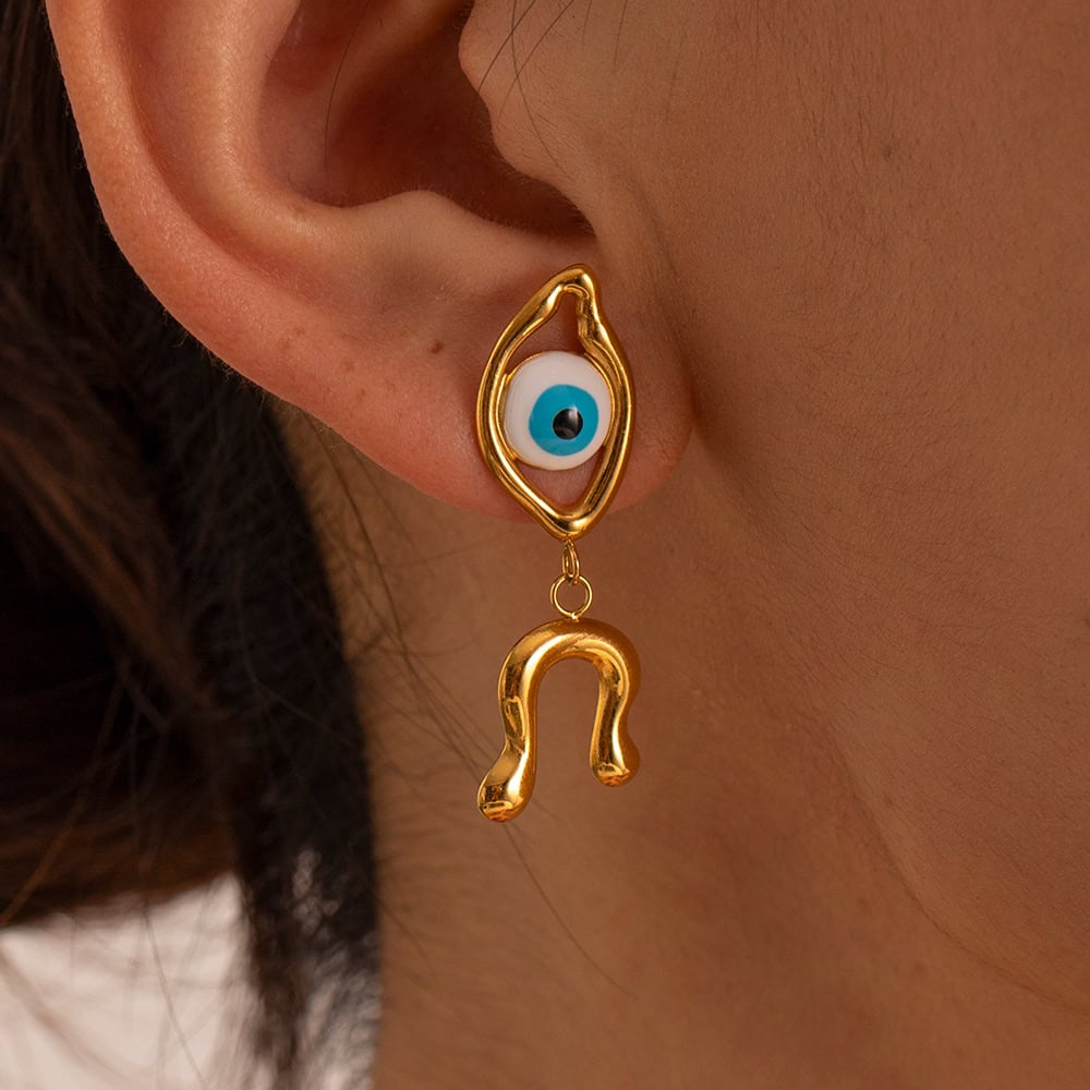 Evil eye gold earring with eye charm and hanging horseshoe attachment, stylish accessory for protection and fashion, perfect for jewelry lovers.