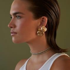 Close-up image of a woman showcasing stylish gold spiral earrings, perfect for enhancing any jewelry collection. Discover high-quality, unique designs at Monalisa Store for sophisticated accessory choices.