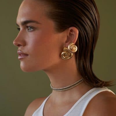 Close-up image of a woman showcasing stylish gold spiral earrings, perfect for enhancing any jewelry collection. Discover high-quality, unique designs at Monalisa Store for sophisticated accessory choices.