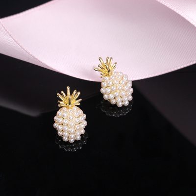 Elegant pineapple-shaped pearl earrings with gold accents, perfect for stylish occasions and jewelry lovers.