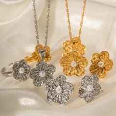 Luxurious jewelry set featuring gold and silver floral pendants with central pearls, perfect for sophisticated fashion and special occasions.