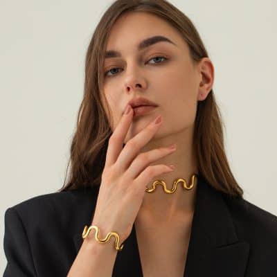 Stylish gold jewelry featuring wavy designs for women, including a necklace, bracelet, and ring from Monalisa Store. Perfect accessories for elegant fashion statements.