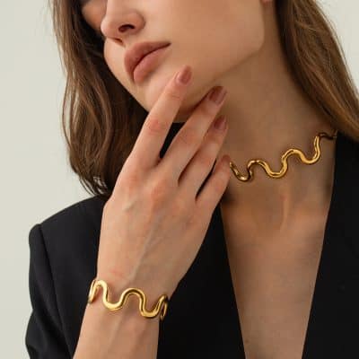 Suitable for women who want modern, stylish jewelry. Featuring a gold wavy necklace and matching bracelet, perfect for enhancing any outfit with luxury accessories.