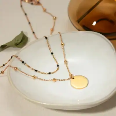 Elegant jewelry necklace set with gold-tone chain, black beads, and round pendant, perfect for stylish accessories.