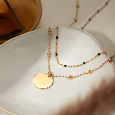 Beautiful gold necklace featuring small black beads, perfect for stylish women seeking premium jewelry. Ideal for accessorizing any outfit with a touch of sophistication.