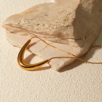 Luxurious gold necklace displayed on a textured background, ideal for women seeking stylish jewelry at Monalisa Store, perfect for enhancing your fashion and jewelry collection.