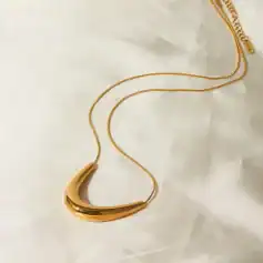 Luxurious gold chain necklace with a sleek, curved pendant, perfect for fashionable women seeking sophisticated jewelry. Ideal for special occasions or everyday wear.
