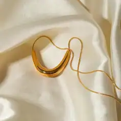 Dainty gold chain with a bold gold pendant, ideal for stylish women's jewelry collection.