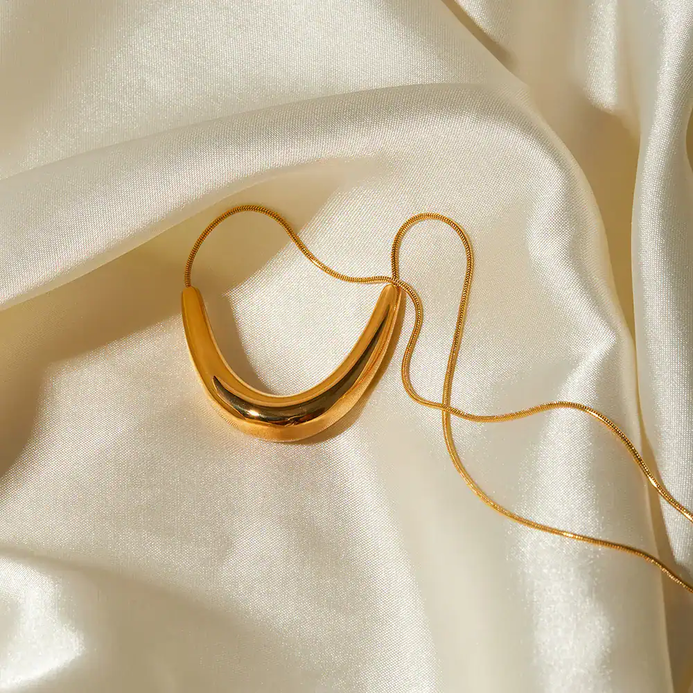 Dainty gold chain with a bold gold pendant, ideal for stylish women's jewelry collection.