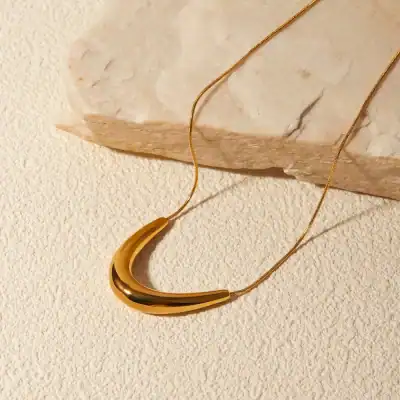 Luxurious gold crescent pendant necklace for women, perfect for fashionable accessories and jewelry lovers. Features a sleek, polished design with a delicate chain, ideal for gift-giving or everyday wear.