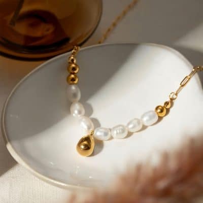 Luxurious pearl and gold beaded necklace displayed on a white dish, perfect for elegant jewelry collections and stylish accessories.