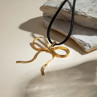 Delicate gold bow necklace with black cord, perfect for luxury jewelry lovers. Classy, stylish, and ideal for special occasions or everyday wear. Shop now at Monalisa Store for premium jewelry.
