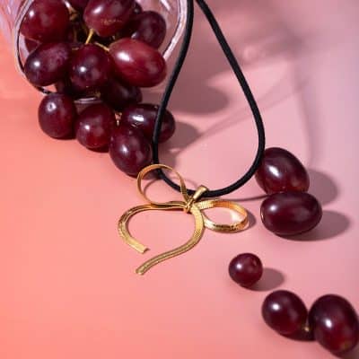 Elegant gold heart pendant necklace paired with fresh red grapes, perfect for stylish accessories or gifting.
