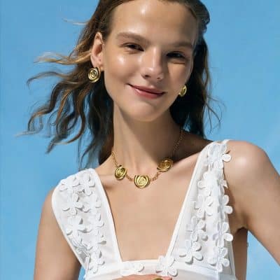 Vibrant photo showcasing a woman wearing stylish gold jewelry, including a necklace and earrings, perfect for women seeking fashionable accessories.