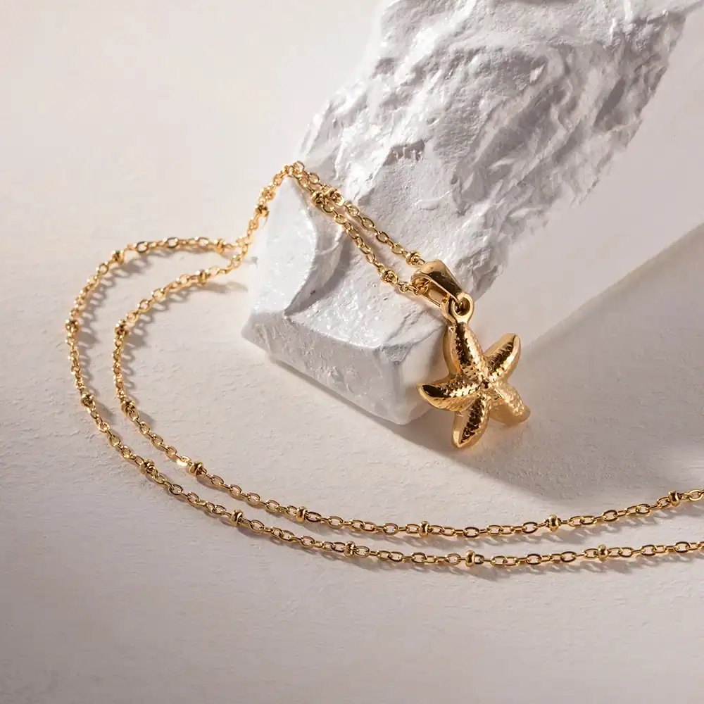 Delicate gold starfish pendant necklace with adjustable chain, perfect for beach-inspired jewelry and everyday wear.