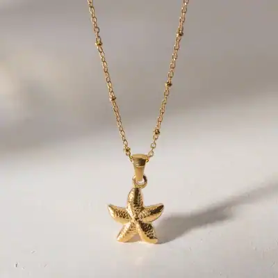 Elegant gold starfish pendant necklace, perfect for ocean-inspired jewelry lovers and beachwear accessories. High-quality craftsmanship suitable for everyday wear or special occasions.