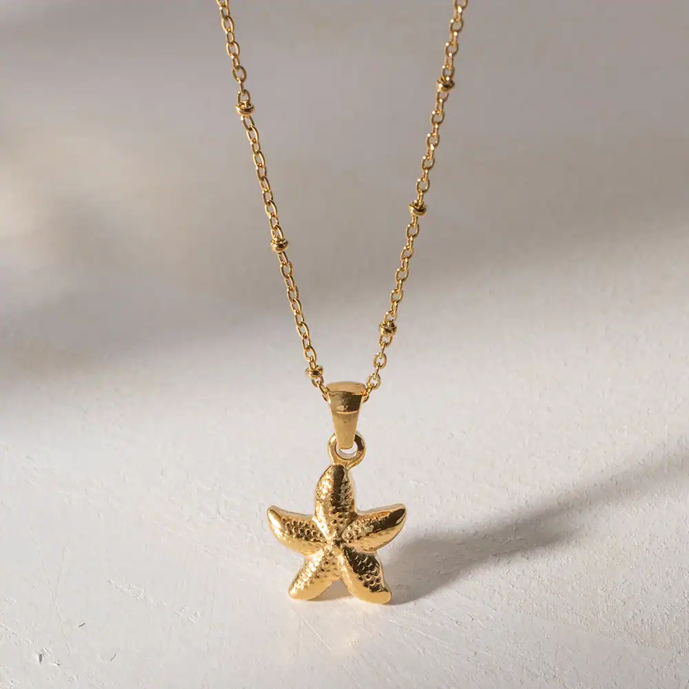 Elegant gold starfish pendant necklace, perfect for ocean-inspired jewelry lovers and beachwear accessories. High-quality craftsmanship suitable for everyday wear or special occasions.