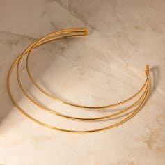 Alternative text: Beautiful gold-tone headband featuring a sleek, minimalist design, perfect for stylish hair accessories and fashion enhancements.