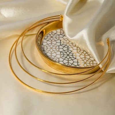 Luxurious gold jewelry with modern design set on satin fabric, showcasing elegant accessories ideal for fashion boutiques and luxury gift items, highlighting premium quality.