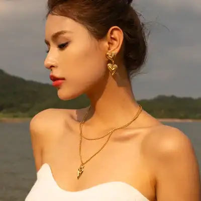 Luxurious gold heart-shaped earrings and layered necklaces, perfect for elegant occasions and stylish accessories.