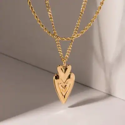 Gold layered chain necklace with heart-shaped pendant, perfect for jewelry and accessories lovers. Stylish and trendy gold jewelry for women and girls.