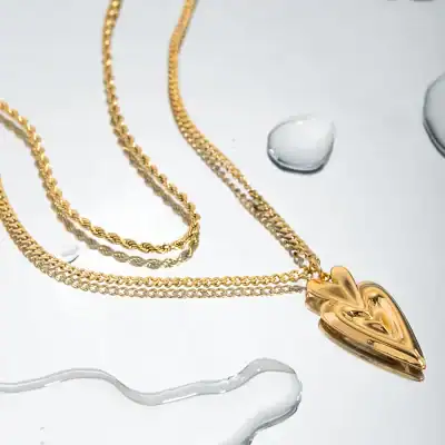 Elegant gold necklace with heart pendant, perfect for stylish women, and layered chain design for chic accessorizing.