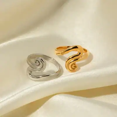 Sleek silver and gold swirl rings featured on satin for stylish, elegant jewelry. Perfect accessories for special occasions or everyday fashion, highlighting quality craftsmanship.