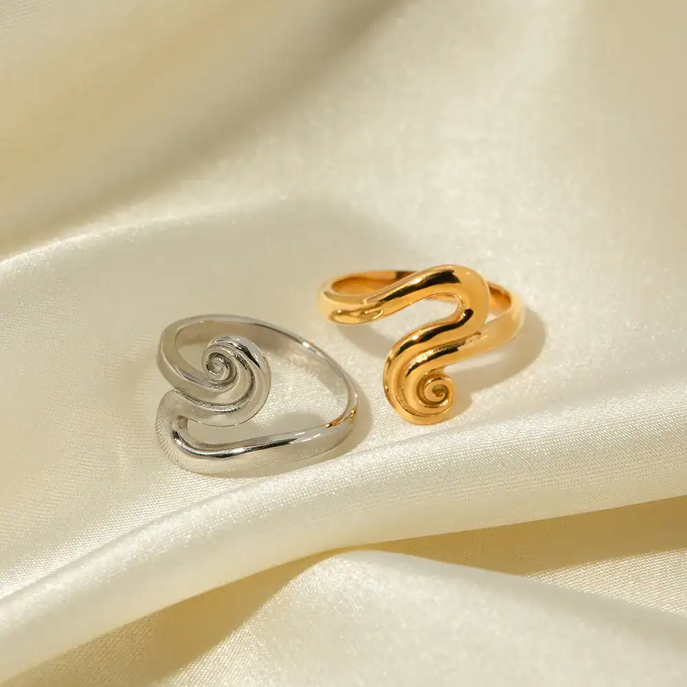 Sleek silver and gold swirl rings featured on satin for stylish, elegant jewelry. Perfect accessories for special occasions or everyday fashion, highlighting quality craftsmanship.