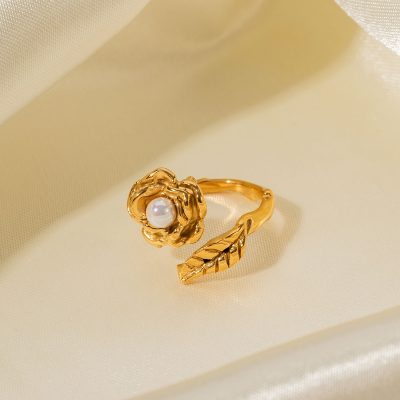 Luxurious gold ring featuring a detailed flower design with a central pearl and a matching leaf-shaped band, ideal for sophisticated jewelry lovers.