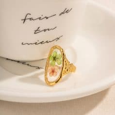 Beautiful floral resin ring featuring colorful pressed flowers in a gold setting, ideal for elegant jewelry collections.