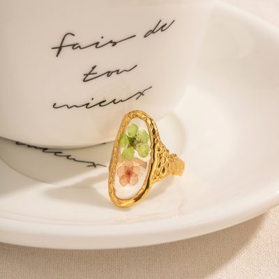 Beautiful floral resin ring featuring colorful pressed flowers in a gold setting, ideal for elegant jewelry collections.