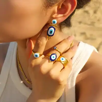 Evil eye jewelry set including rings and earrings with blue eye motifs, made of gold-tone metal, perfect for protection and style, ideal for gifting or personal fashion statement.