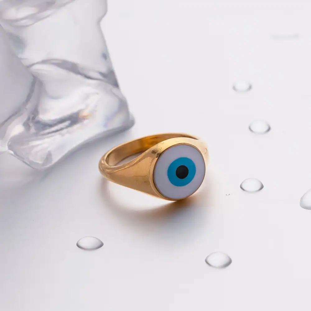 Evil eye ring with gold band and blue eye design, perfect for fashion statement and protection.
