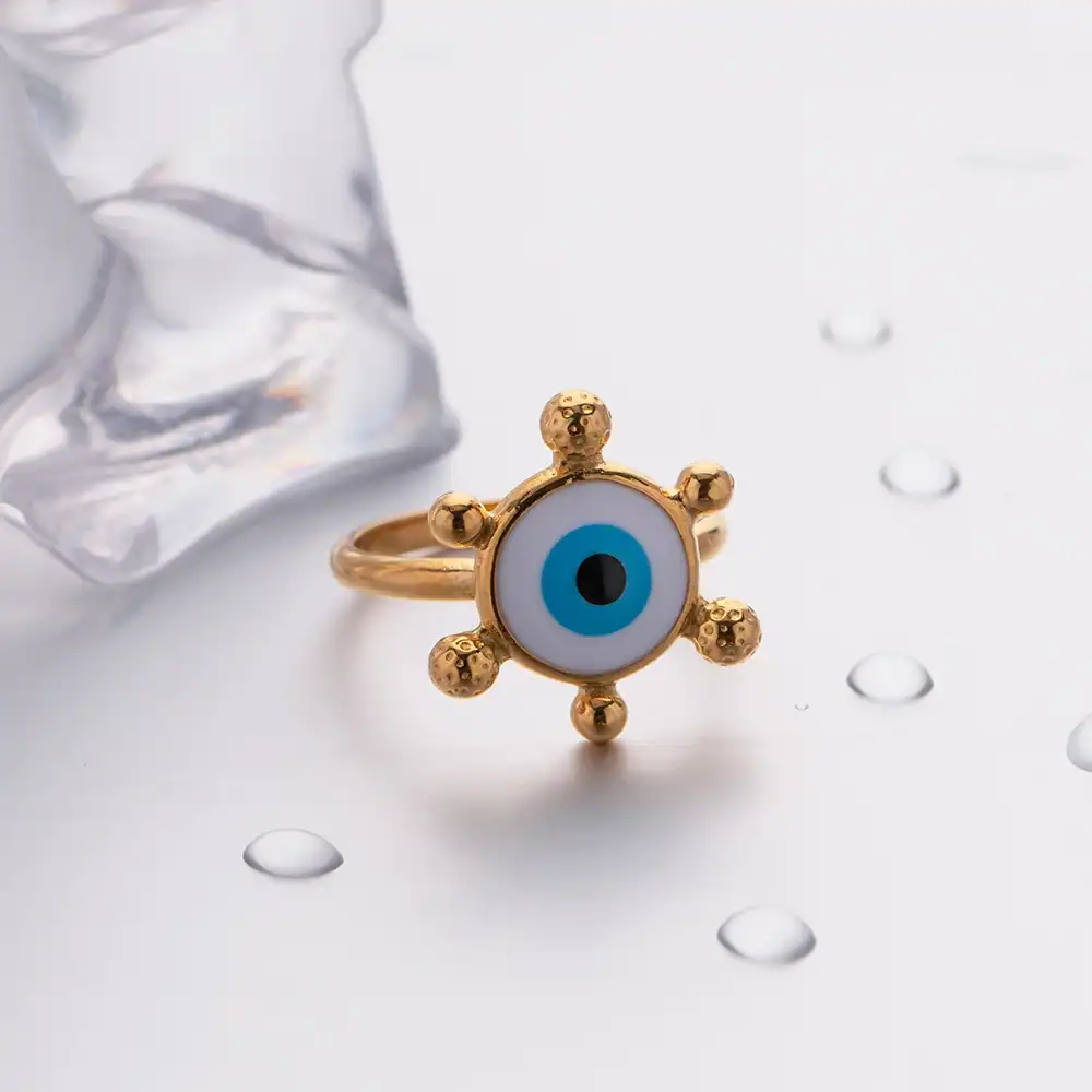 Gold evil eye ring with blue and black eye design, trendy jewelry piece, perfect for protection and fashion statement.