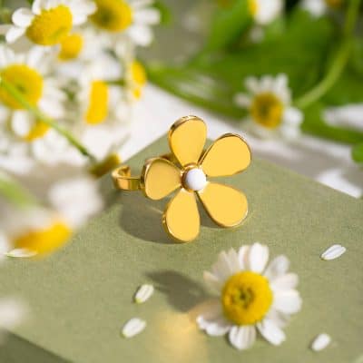 A beautiful flower-shaped ring with gold petals and a white center, designed for stylish fashion statements and ideal for gift-giving.