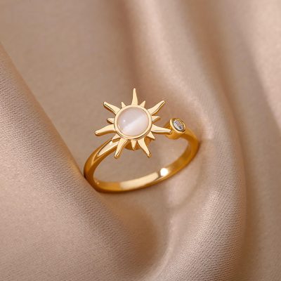 Delicate gold ring featuring a sun motif with a gemstone center and a small sparkling stone on the side, perfect for adding a touch of elegance to your look.