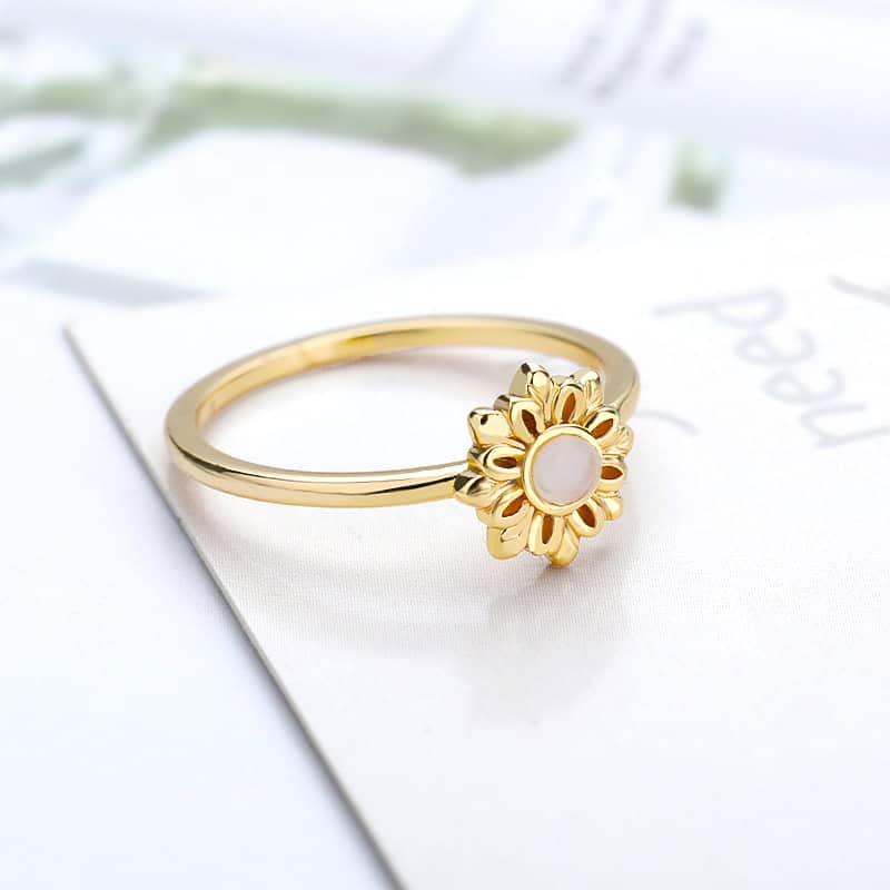 Elegant gold sunflower ring with a pearl center, perfect for stylish jewelry lovers.