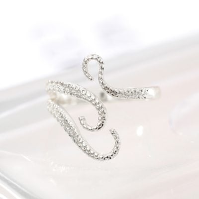 Delicate silver ear cuff shaped like an octopus with sparkling eye details, perfect for stylish accessories and ear jewelry lovers.