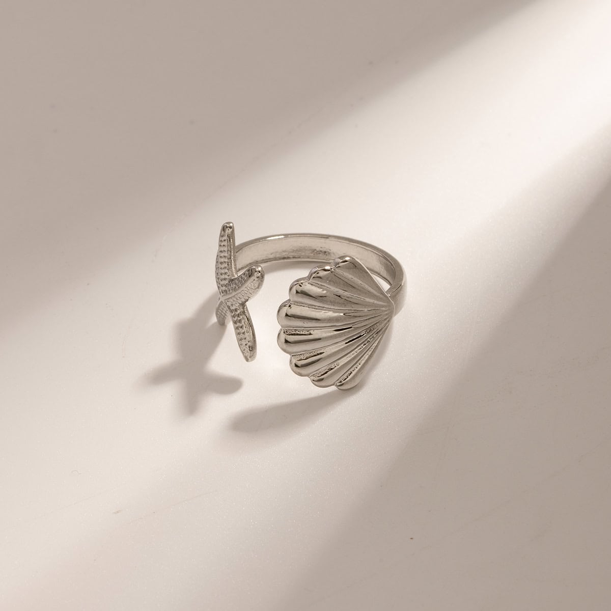 Sterling silver ring featuring a starfish and scallop shell motif, perfect for beach-inspired jewelry lovers and coastal fashion accessories.