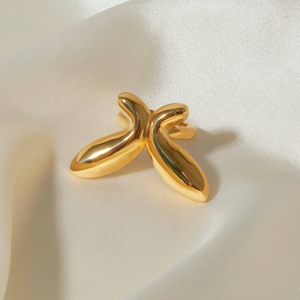 Stunning gold butterfly-shaped ring displayed on silky white fabric, perfect for fashion-forward jewelry lovers and accessorizing.
